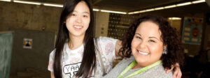 A smiling high-school student posing with her tutor, preparing for post-secondary.