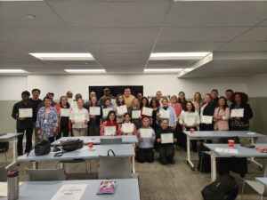 Group photo where people hold certificates.